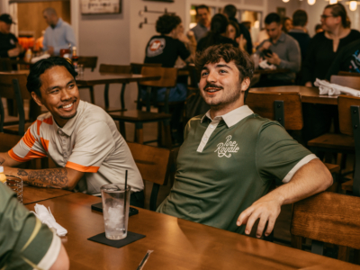Guests laughing at a table in the Pine Royale restaurant, one in a Pine Royale polo