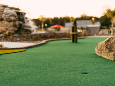 A Mini Royale green and cup, the rock waterfall behind at sunset