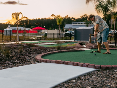 A player taps in a putt on a Mini Royale hole as the sun sets